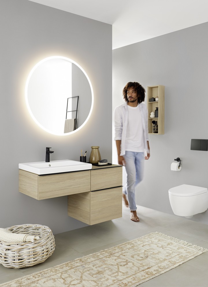 Man in a bathroom with round Geberit Option mirror