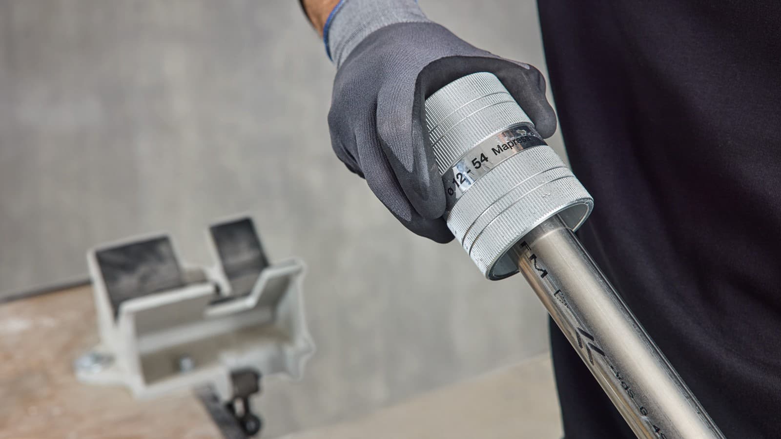 Deburring a Geberit Mapress system pipe after cutting to length with a saw